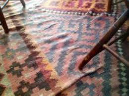 Wrinkled area rug on hardwood floor caused by humidity and heavy furniture