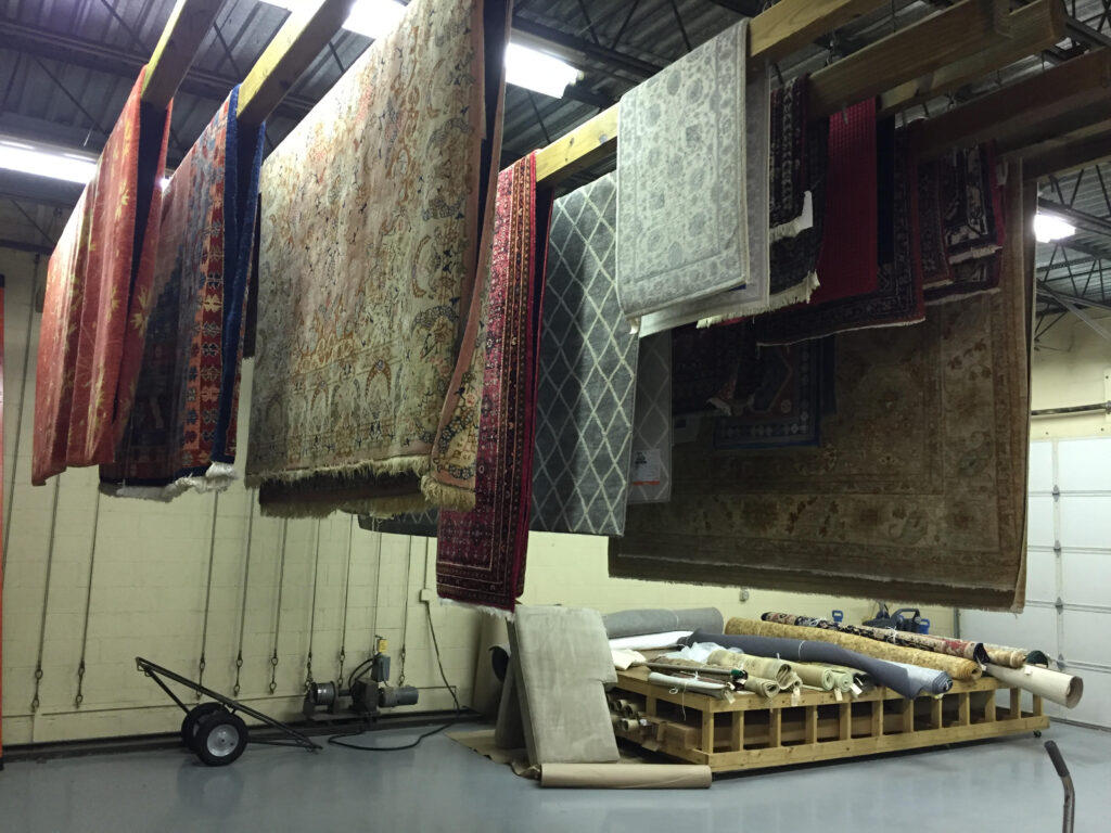 Cleaned Oriental area rugs hanging to dry at Alec’s Carpet & Upholstery Cleaning plant serving Hingham MA