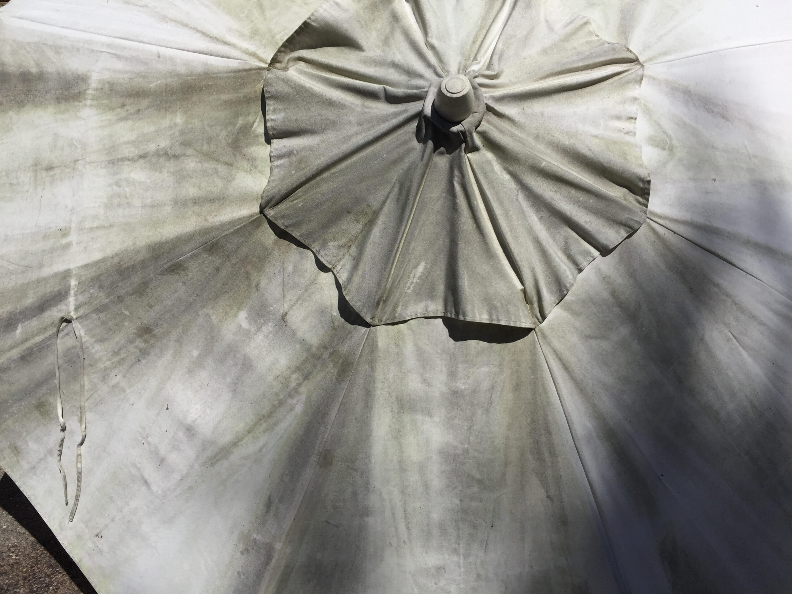 Outdoor patio umbrella before professional cleaning.