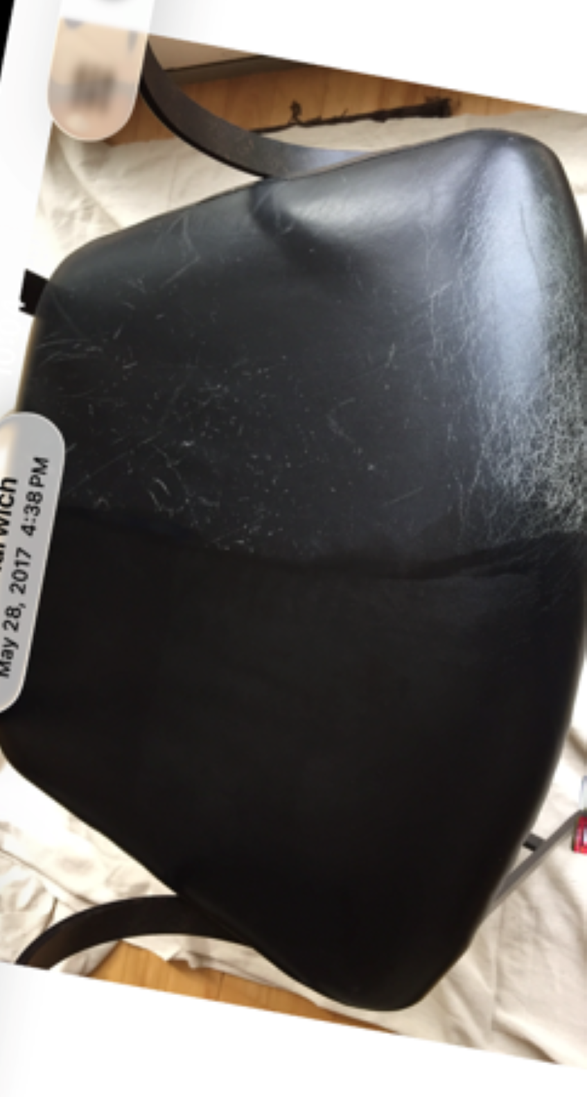 Black protected leather chair seat showing one half restored and one half worn for comparison.